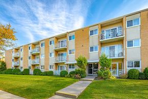 Kitchener apartment for rent - A row of apartment buildings with balconies and green lawns in front.