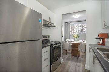 Kitchener apartment for rent - A modern kitchen with a stainless steel refrigerator and a dining table set for two.