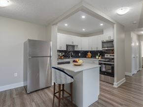 London apartment for rent - A kitchen with a refrigerator, island, and stove.