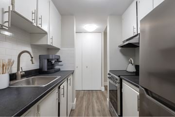 Halifax apartment for rent - A modern kitchen with white cabinets and stainless steel appliances.