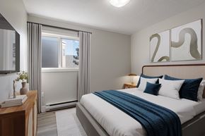 Halifax apartment for rent - A bedroom with a bed, nightstand, and window with curtains.