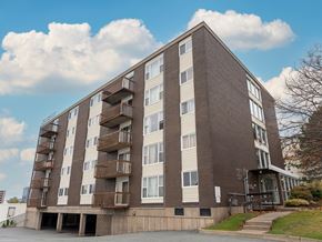 Halifax apartment for rent - A large apartment building with a brown and beige exterior and balconies on the second floor.