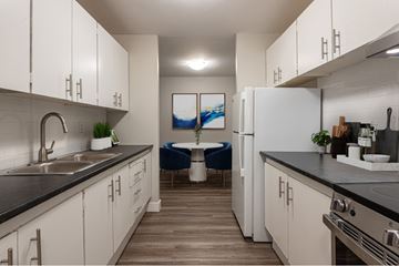 Bedford apartment for rent - A modern kitchen with white cabinets and a black countertop.