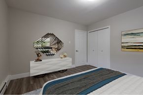 Halifax apartment for rent - A bedroom with a bed, a mirror, and a painting on the wall.