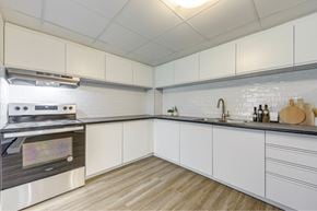 Thorold apartment for rent - A modern kitchen with a stove and white cabinets.
