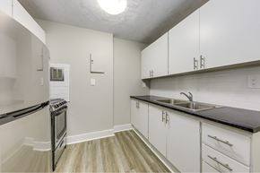 Cambridge apartment for rent - A kitchen with white cabinets and a black counter top.