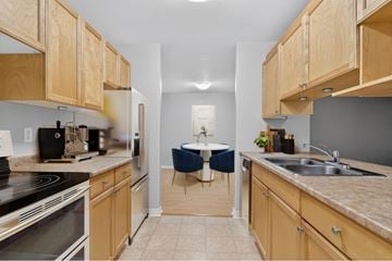 Moncton apartment for rent - A kitchen with wooden cabinets and a table set for two.