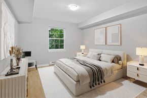 Moncton apartment for rent - A bedroom with a large bed, a nightstand, and a window.