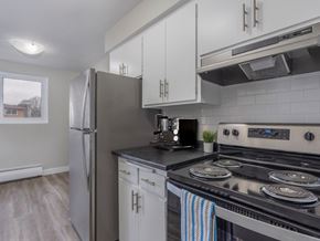 Hamilton apartment for rent - A modern kitchen with a stainless steel stove and white cabinets.