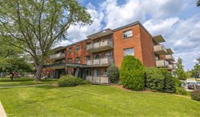 Hamilton apartment for rent - A red brick apartment building with a green lawn in front.