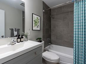 Hamilton apartment for rent - A bathroom with a white sink, a toilet, a bathtub, and a shower curtain.