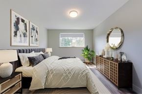 Kitchener apartment for rent - A bedroom with a large bed and a mirror on the wall.