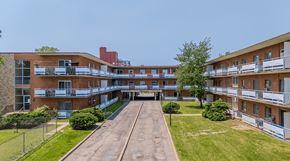 Hamilton apartment for rent - A long building with a balcony on the second floor.