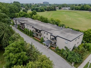 London apartment for rent - A large grey building with a green lawn in front.