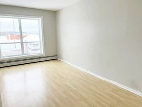 Moncton apartment for rent - A room with a large window and wooden flooring.