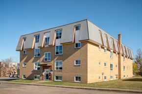 Moncton apartment for rent - A modern building with a combination of brick and siding exterior.