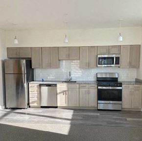 Suitland apartment for rent - A kitchen with a refrigerator, microwave, oven, and sink.