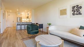 Los Angeles apartment for rent - A living room with a white couch, a green chair, and a white coffee table.