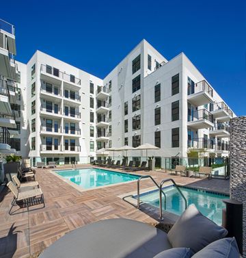 Hollywood apartment for rent - A large white building with a pool in front.