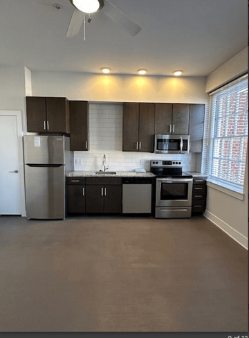 Richmond apartment for rent - A kitchen with a refrigerator, microwave, oven, and sink.