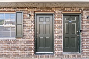 Summerville apartment for rent - A brown brick wall with three doors.
