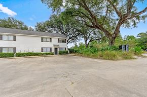 Summerville apartment for rent - A large tree is in front of a two-story building.