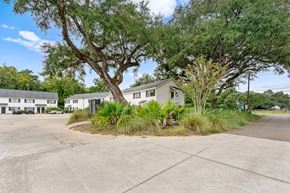 Summerville apartment for rent - A tree in a parking lot with a building in the background.