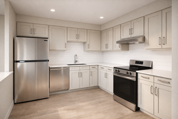 South Hamilton apartment for rent - A modern kitchen with stainless steel appliances and white cabinetry.