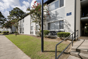Savannah apartment for rent - A white building with a blue sign on the front at Retreat at Savannah Apartments, Savannah, GA, 31404