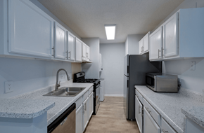 Savannah apartment for rent - A kitchen with white cabinets and a black refrigerator at Retreat at Savannah Apartments, Georgia, 31404