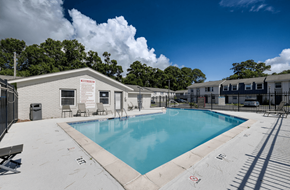 Savannah apartment for rent - A swimming pool surrounded by a concrete patio and a small building at Savan Pointe Apartments, Savannah, GA, 31406