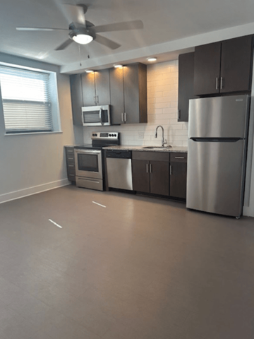 Richmond apartment for rent - A modern kitchen with a refrigerator, microwave, and oven.