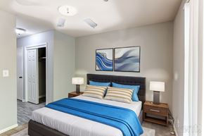 Perry apartment for rent - A bedroom with a bed, two lamps on nightstands, and a ceiling fan.