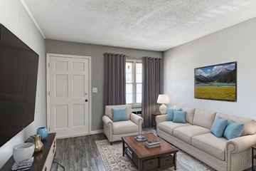 Perry apartment for rent - A living room with a couch, a coffee table, and a painting on the wall.