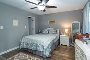 Hawkinsville apartment for rent - A bedroom with a bed, nightstand, dresser, and a ceiling fan.