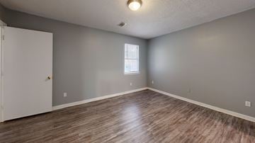 Hawkinsville apartment for rent - A room with a white door and a window with a wooden floor.