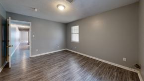 Hawkinsville apartment for rent - A room with a wooden floor and a ceiling fan.