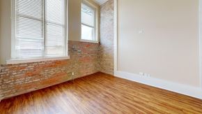 Macon apartment for rent - A room with a brick wall and wooden flooring.