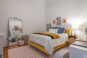 Macon apartment for rent - A bedroom with a bed, a mirror, and a desk.