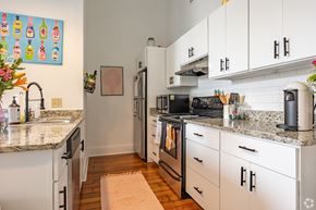Macon apartment for rent - A kitchen with white cabinets and granite countertops.