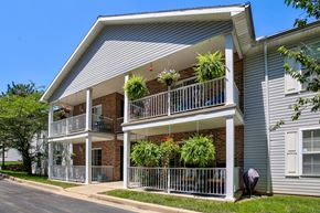 Evansville apartment for rent - A two-story building with a balcony and a metal railing.