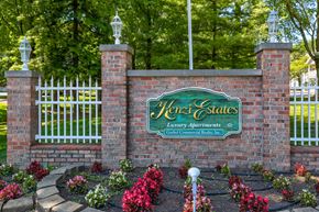 Evansville apartment for rent - A sign for Kenzi Estates is displayed in front of a white fence.