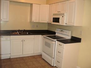 Newburgh apartment for rent - A white kitchen with black countertops and white appliances.