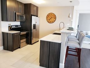 Evansville apartment for rent - a kitchen with stainless steel appliances and a counter with a kitchen island and a clock