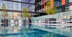 Chicago apartment for rent - A modern building with a pool in front.