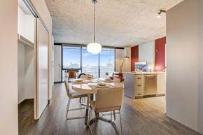 Chicago apartment for rent - A dining room with a table set for two with a view of the city outside the window.