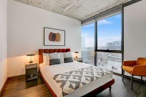 Chicago apartment for rent - A bedroom with a large bed and a chair.