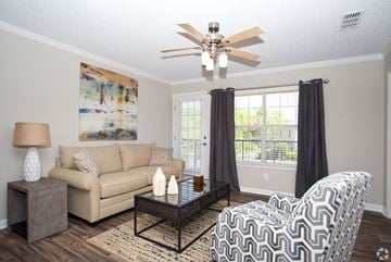 Auburn apartment for rent - A living room with a beige couch, a black and white chair, and a painting on the wall.