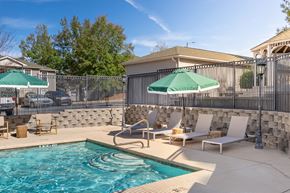 Auburn apartment for rent - A pool with a stone wall and a fence.