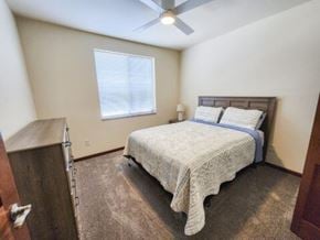 Rapid City apartment for rent - A bedroom with a bed, a ceiling fan, and a window.